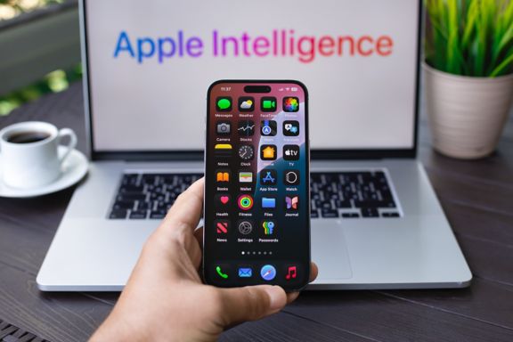 Alanya, Turkey - September 16, 2024: Man hand holding Apple Macbook Pro and iPhone 15 Pro Max with home screen AI Apple Intelligence Siri on the screen macOS Sequoia and IOS 18.