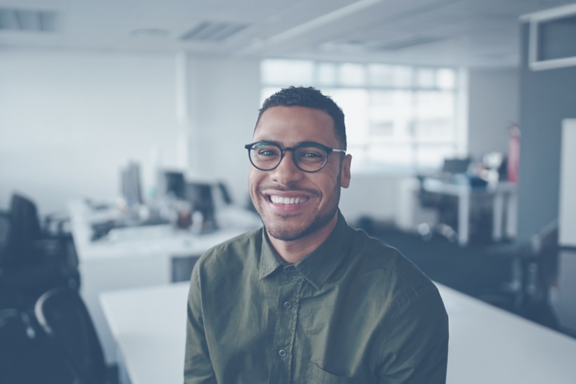 Portrait of a positive young professional businessman in his office