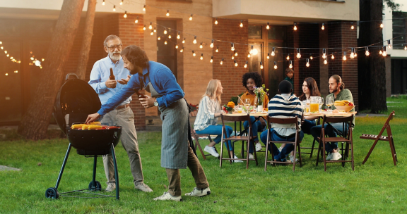 Des personnes autour d'un barbecue pour un repas convivial