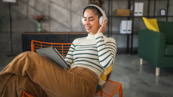 Beautiful young couple in love at home, celebrating with a gift box exchange, kissing