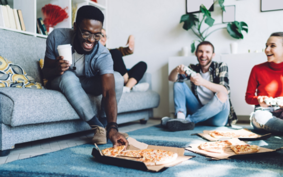 Beautiful young couple in love at home, celebrating with a gift box exchange, kissing