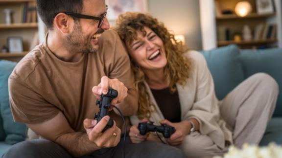 Beautiful young couple in love at home, celebrating with a gift box exchange, kissing
