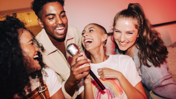Beautiful young couple in love at home, celebrating with a gift box exchange, kissing