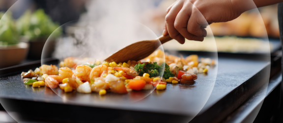Colorful shrimp vegetables and rice sizzling on Blackstone street food griddle scene , Selective Focus