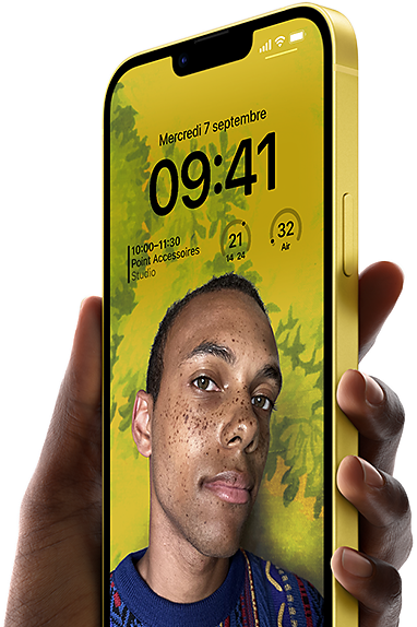Main tenant un iPhone 14 Plus jaune sur lequel figure un écran verrouillé personnalisé.