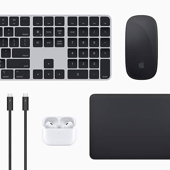 Accessoires Mac vus d’en haut : Magic Keyboard, Magic Mouse, Magic Trackpad, AirPods et câbles Thunderbolt