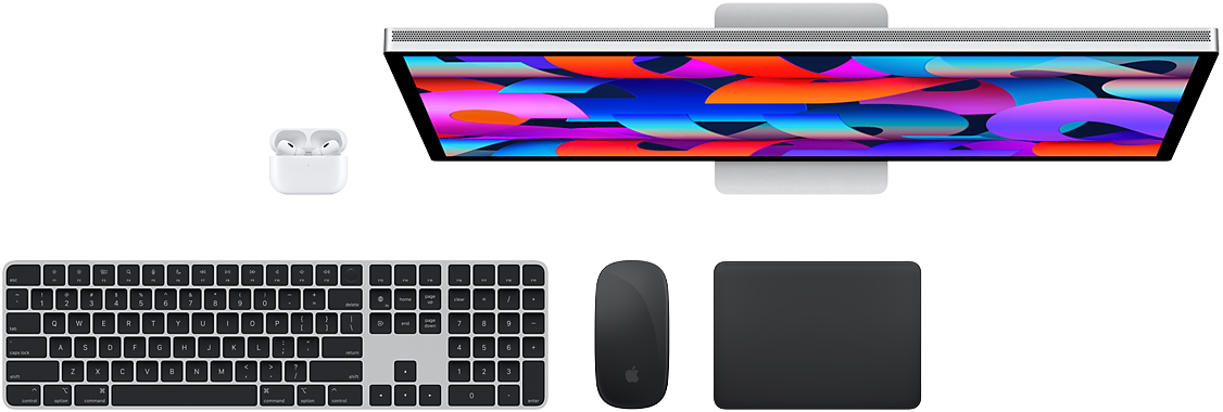 Accessoires Mac vus d’en haut : Studio Display, AirPods, Magic Keyboard, Magic Mouse et Magic Trackpad